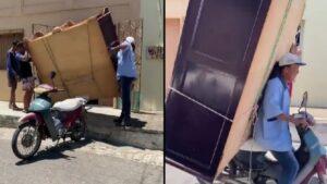 man transports a massive wardrobe by bike